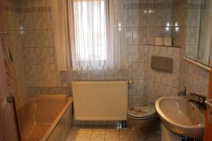 a bathroom with a tub and a toilet and a sink at Caro's Ferienwohnung in Haard +9 photos