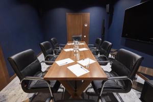 una sala conferenze con un lungo tavolo e sedie in legno di AmstelSki a Bukovel