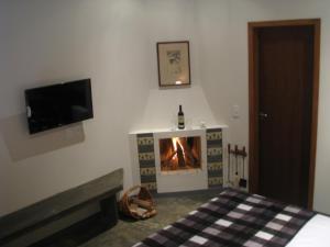 a bedroom with a fireplace with a tv and a bed at Pousada Morena SFX in São Francisco Xavier