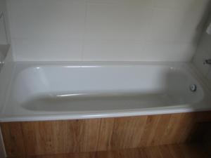 a white bath tub sitting on top of a wooden floor at Pousada Morena SFX in São Francisco Xavier