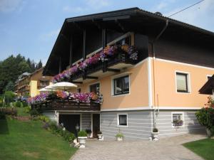 un edificio con cajas de flores en el balcón en Gästehaus Stroitz en Drobollach am Faakersee