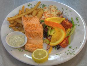 a plate of food with fish and french fries at Queenstown Motor Lodge in Queenstown