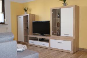 a living room with a television on a entertainment center at Caro's Ferienwohnung in Haard