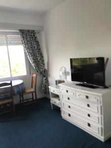 a living room with a flat screen tv on a dresser at Golf Tower in Atlántida
