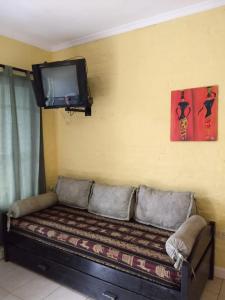 Habitación con sofá y TV en la pared. en Avellaneda 1247 en Tandil