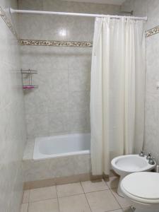a bathroom with a tub and a toilet and a sink at Avellaneda 1247 in Tandil