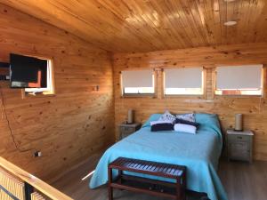 1 dormitorio con 1 cama en una cabaña de madera en Condominio Privado a Pasos del Mar, en Pichilemu