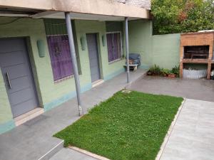 a green house with a lawn in front of it at Avellaneda 1247 in Tandil