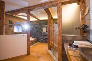 a bathroom with wooden walls and a sink and a refrigerator at Luxus Ferienwohnung Almhütte in Brixen im Thale +41 photos