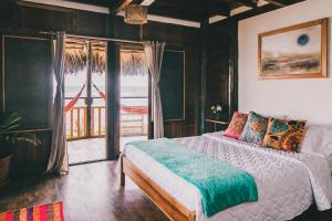 a bedroom with a bed with a view of the ocean at Cuna Luna Hosteria in Olón