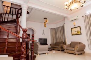 a living room with a staircase and chairs and a television at Rio 6a homestay in Vung Tau
