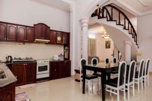 a kitchen with a table with chairs and a staircase at Rio 6a homestay in Vung Tau