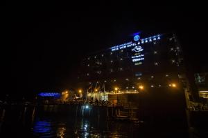 a building lit up at night with people standing outside at Wave View Hotel in Semporna