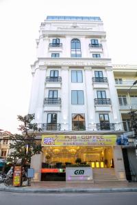 a white building with a store in front of it at GM Hotel and Apartment in Hai Phong