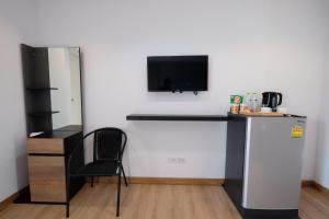 a room with a refrigerator and a tv on a wall at Living at Sphere Apartment in Ao Nang Beach