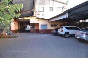 un estacionamiento con autos estacionados frente a un edificio en Hotel Rukalaf, en Chillán