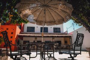 un tavolo e sedie sotto un ombrellone su un patio di Casa Teotitlán a Città di Oaxaca