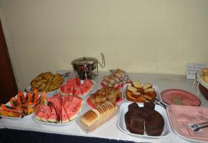 Hotel Capriccio Mauá في مويا: طاولة عليها أنواع مختلفة من الطعام