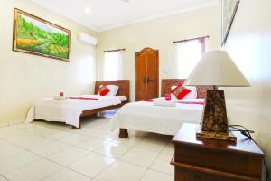 Postel nebo postele na pokoji v ubytování Jungut Guest House Ubud