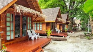 a wooden house with chairs and a wooden deck at Lipe Beach Resort in Ko Lipe