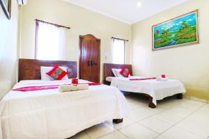 Postel nebo postele na pokoji v ubytování Jungut Guest House Ubud