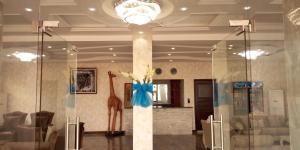a lobby with a pillar with a giraffe on it at Noahgarden Hotel in Cotonou