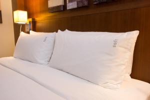 a white bed with a white comforter and pillows at Holiday Inn Abu Dhabi, an IHG Hotel in Abu Dhabi