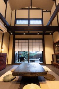 a large wooden table in a room with a large window at Zaimoku-an in Kanazawa