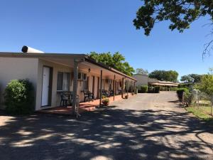 a building with a porch next to a street at Wagon Wheel Motel in Cloncurry