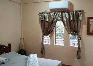 AN Velayo Homestay (ANVEL) في باسكو: غرفة نوم مع سرير ونافذة مع لاب توب