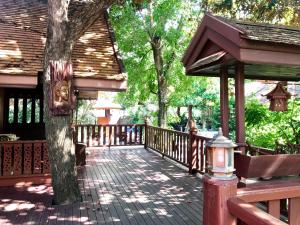 a wooden deck with a tree and a building at Kawila126 in Chiang Mai