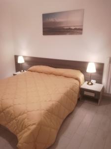 una camera con un grande letto e due lampade di Al Centro di Avellino, Casa vacanze Positano ad Avellino