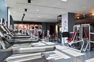 a gym with a row of treadmills and machines at Yas Island Rotana Abu Dhabi in Abu Dhabi
