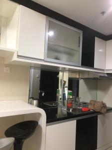 a kitchen with white cabinets and a black counter top at Nagoya Mansion Apartment Batam in Nagoya