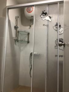 a shower door with stickers on it in a bathroom at Nagoya Mansion Apartment Batam in Nagoya