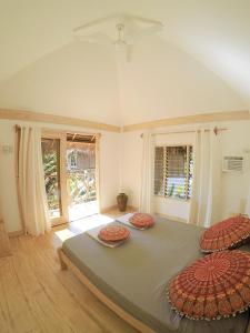 a bedroom with a large bed with three pillows on it at Mandala Tribe Treehouses in Siquijor