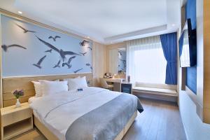 um quarto com uma cama grande com pássaros na parede em Ramada by Wyndham Istanbul Old City em Istambul