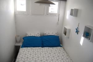 a small bedroom with a bed with blue pillows at T1Bis centre d'Arcachon avec balcon in Arcachon