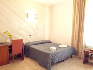 a bedroom with a bed with two towels on it at Hotel San Martino in Cassibile