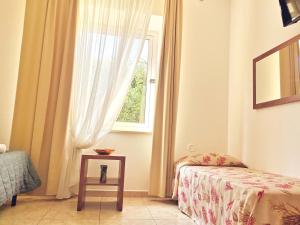 a bedroom with a bed and a window with a table at Hotel San Martino in Cassibile