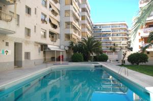 a swimming pool in front of a building at Apartamentos Indasol in Salou