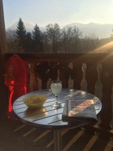 uma mesa com um copo de vinho e um livro em LES CARROZ LE LAYS cosy apartment 40M2 vue montagne plein sud em Les Carroz d'Arâches