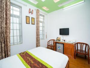 sypialnia z łóżkiem, telewizorem i oknami w obiekcie Phuong Dong hotel w mieście Hanoi