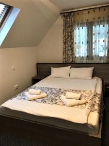 ein Schlafzimmer mit einem Bett und zwei Kissen darauf in der Unterkunft Complex SummerTime in Cavnic