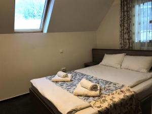 ein Schlafzimmer mit einem Bett, auf dem zwei Handtücher liegen in der Unterkunft Complex SummerTime in Cavnic + 17 Fotos