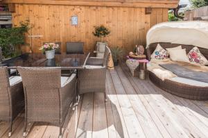 un patio con sillas de mimbre y una mesa en una terraza. en Apartchalet Almliebe en Maria Alm am Steinernen Meer