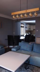 a living room with a couch and a table at Villa Akant - Apartamenty w Karkonoszach in Piechowice