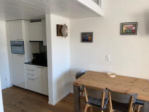eine Küche und ein Esszimmer mit einem Holztisch und Stühlen in der Unterkunft Studio Top im des Alpes in Flims