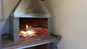 un horno de ladrillo con un fuego dentro de él en Casalesanpietro, en Castellabate