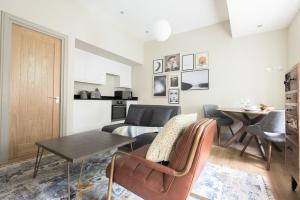 The New Bond Street Loft - Modern & Central 1BDR في لندن: غرفة معيشة مع طاولة وأريكة
